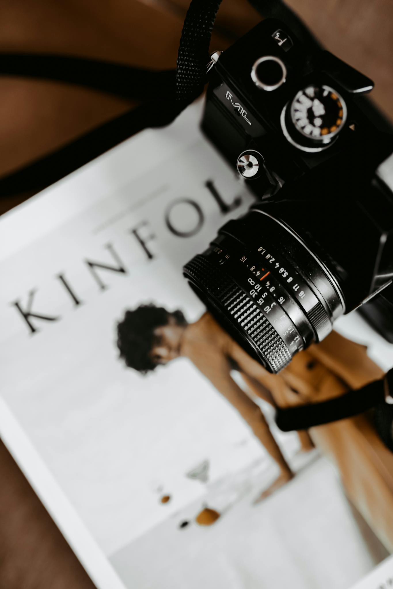Styled flat lay featuring a vintage camera on a Kinfolk magazine, creating a modern aesthetic.